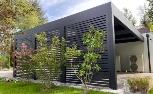 Carport en bois abritant une voiture électrique près de sa borne de recharge